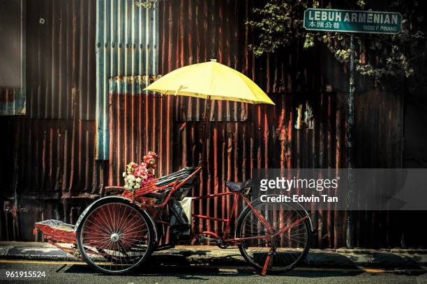 fietstaxi met gele paraplu op de back-straat in penang - george town penang stockfoto's en -beelden
