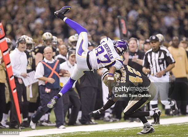 Bernard Berrian of the Minnesota Vikings is upended by Darren Sharper of the New Orleans Saints during the NFC Championship Game against the New...