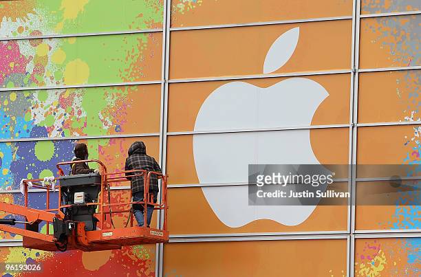 Workers apply the Apple logo to the exterior of the Yerba Buena Center for the Arts in preparation for an Apple special event January 26, 2010 in San...