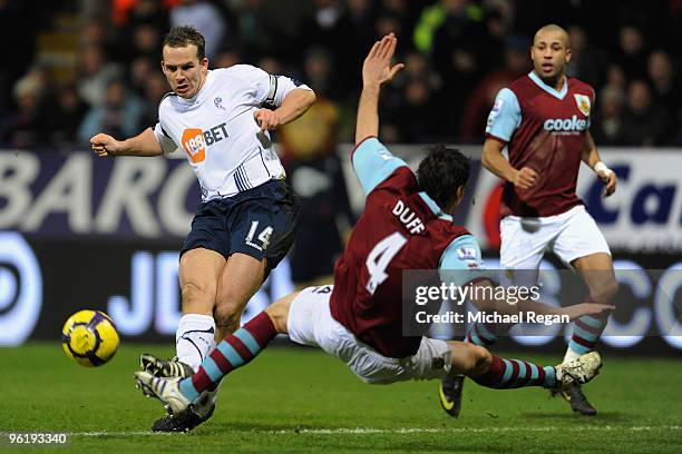 Kevin Davies of Bolton shoots past Michael Duff of Burnley during the Barclays Premier League match between Bolton Wanderers and Burnley at the...