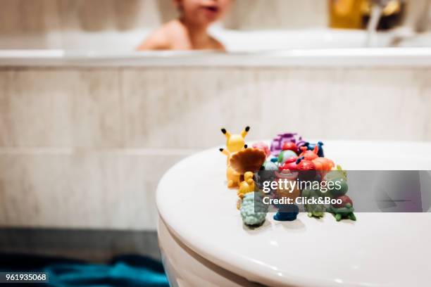 boy in bath with little plastic dolls - click&boo stock pictures, royalty-free photos & images