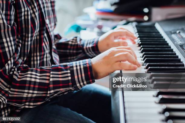 close up of the hands of a boy playing the piano. - click&boo bildbanksfoton och bilder