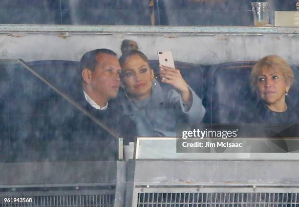 Former MLB player Alex Rodriguez and singer Jennifer Lopez take a photograph during a rain delay of a game between the New York Yankees and the...