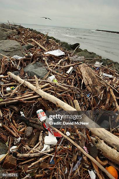 Trash and debris from the run-off of recent storms litters a jetty and beach near the mouth of the San Gabriel River as another storm moves in on...