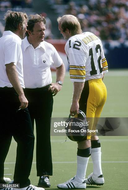 Head Coach Chuck Noll of the Pittsburgh Steelers talking with his quarterback Terry Bradshaw on the sidelines during a mid circa 1970's NFL football...
