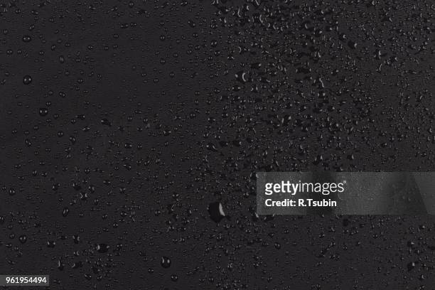 water drops on dark stone rock surface of basalt or granite - gota agua fotografías e imágenes de stock