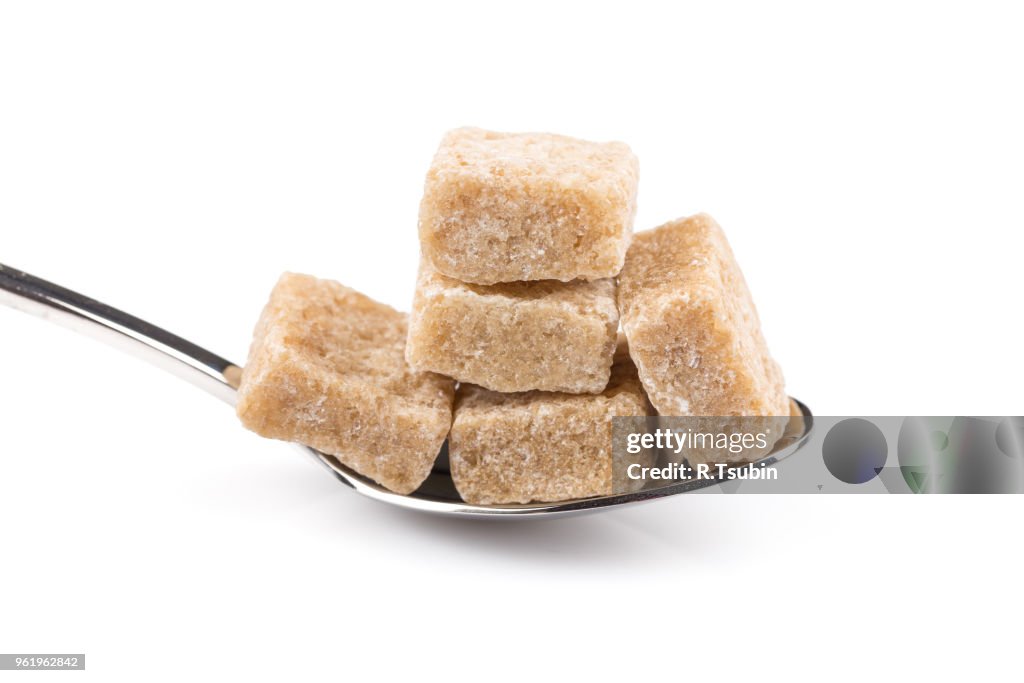 Cubes of brown sugar on a metal spoon