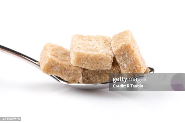 cubes of brown sugar on a metal spoon - panela stock pictures, royalty-free photos & images