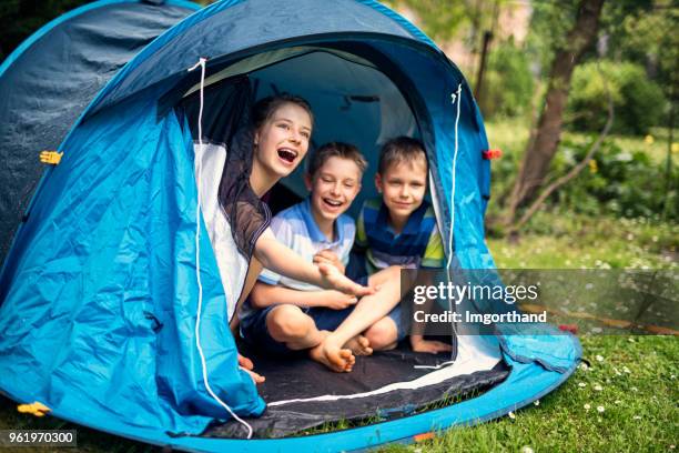 kinder spielen im zelt im garten camping - tent stock-fotos und bilder