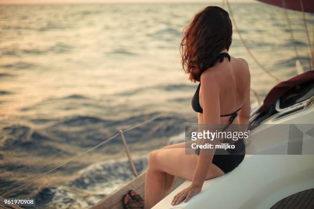 woman sitting on sailboat deck while sailing - miljko stock pictures, royalty-free photos & images