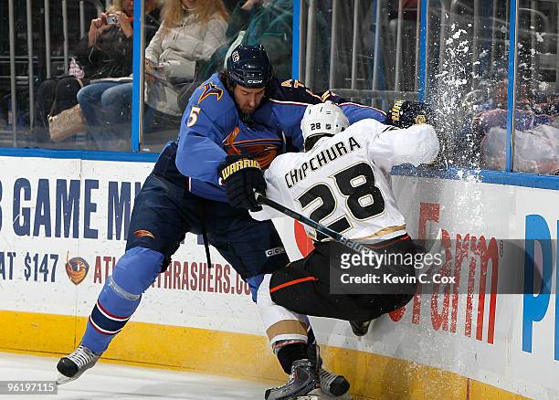 Kyle Chipchura of the Anaheim Ducks is checked into the boards by Boris Valabik of the Atlanta Thrashers at Philips Arena on January 26, 2010 in...