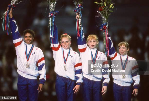 Betty Okino, Sandy Woolsey, Amy Scherr, and Kim Zmeskal of the United States Women's Gymnastics Team wave to the crowd during the awards ceremony for...