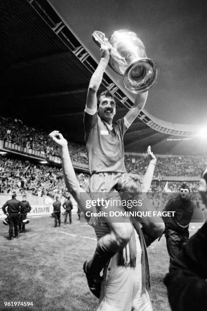 Liverpool's English defender Alan Kennedy sits on a teammates's shoulders as he raises the trophy while celebrating winning the European Cup final...
