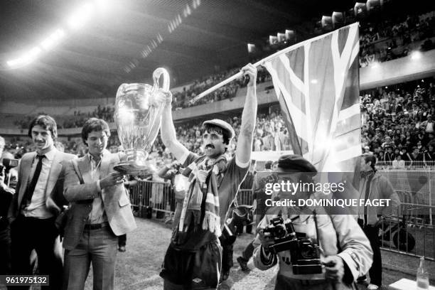 Liverpool's English forward David Johnson holds the trophy as he celebrates winning the European Cup final football match between Liverpool and Real...