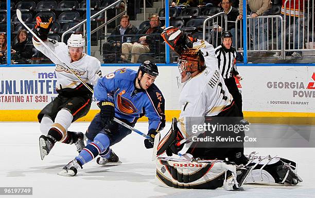 James Wisniewski slips up as goaltender Jonas Hiller of the Anaheim Ducks defends a shot on goal by Marty Reasoner of the Atlanta Thrashers at...