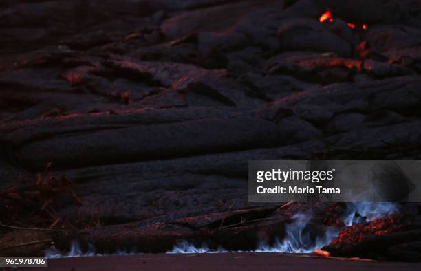 Blue flames of methane gas escape from a crack near a Kilauea volcano fissure in Leilani Estates, on Hawaii's Big Island, on May 23, 2018 in Pahoa,...