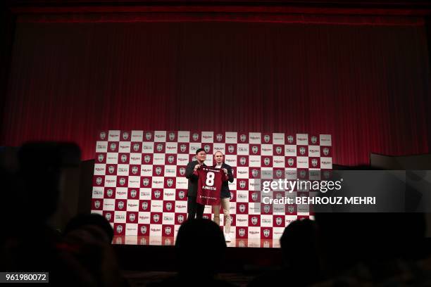 Spanish football star Andres Iniesta and Hiroshi Mikitani, owner of Rakuten and Vissel Kobe club, hold Iniesta's new jersey during a press conference...