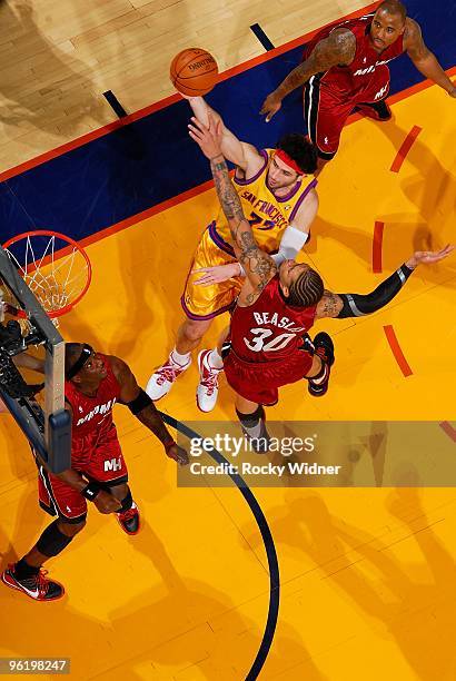 Vladimir Radmanovic of the Golden State Warriors hooks a shot over Michael Beasley of the Miami Heat during the game on January 13, 2010 at Oracle...