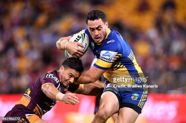 Bradley Takairangi of the Eels takes on the defence of Kodi Nikorima of the Broncos during the round 12 NRL match between the Brisbane Broncos and...