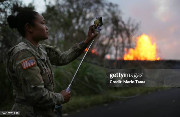 National Guard soldier takes photos as lava erupts and flows from a Kilauea volcano fissure in Leilani Estates, on Hawaii's Big Island, on May 23,...