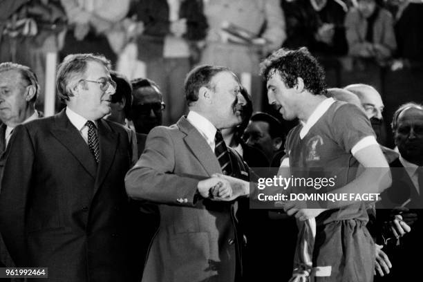 Liverpool's English defender Alan Kennedy is congratulated by an unidentified man as French Prime Minister Pierre Mauroy looks on after Liverpool won...