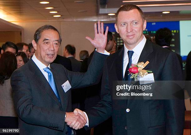 Oleg Deripaska, chief executive officer of United Co. Rusal Ltd., right, shakes hands with Ronald Arculli, chairman of the Hong Kong Exchanges &...