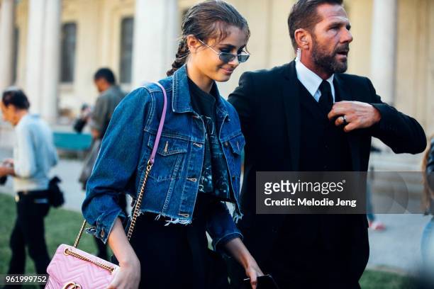Model Taylor Hill exits the Alberta Ferretti show with a bodyguard and wears a thin sunglasses, a cropped denim jacket, and pink Gucci bag during...