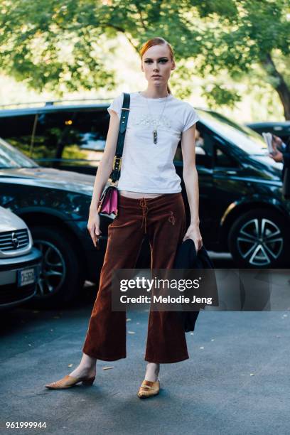 Model Kiki Willems wears a 90s style white shirt, brown wide legged pants, and crocodile slippers during Milan Fashion Week Spring/Summer 2018 on...