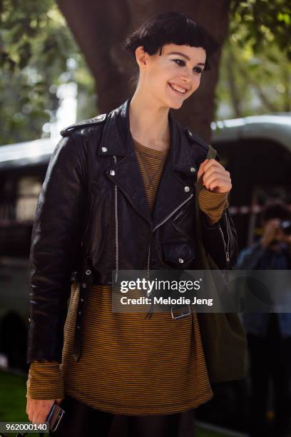 Model Irina Shnitman exits the Armani show in hair and makeup, wears a cropped leather jacket and yellow striped shirt during Milan Fashion Week...