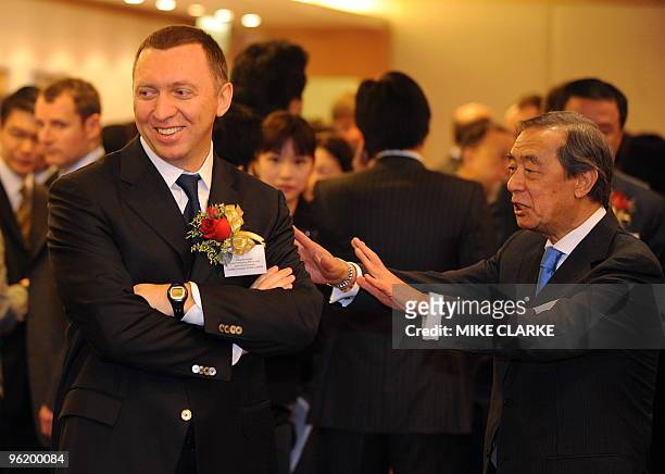 Oleg Deripaska, Chief Executive Officer of Russian metals giant UC Rusal smiles as he listens to Chairman of the Hong Kong Stock Exchange Ronald...