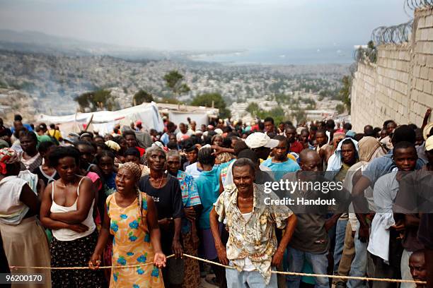 In this handout image provided by the United Nations Stabilization Mission in Haiti , people wait to collect water as the Agency for Technical...