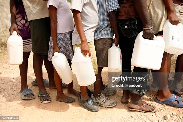 In this handout image provided by the United Nations Stabilization Mission in Haiti , people wait to collect water as the Agency for Technical...