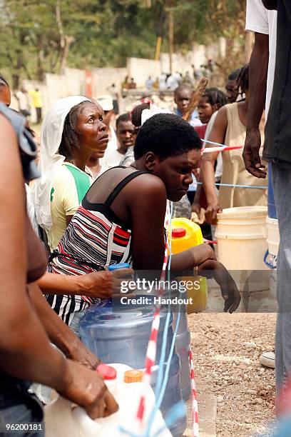 In this handout image provided by the United Nations Stabilization Mission in Haiti , people wait to collect water as the Agency for Technical...