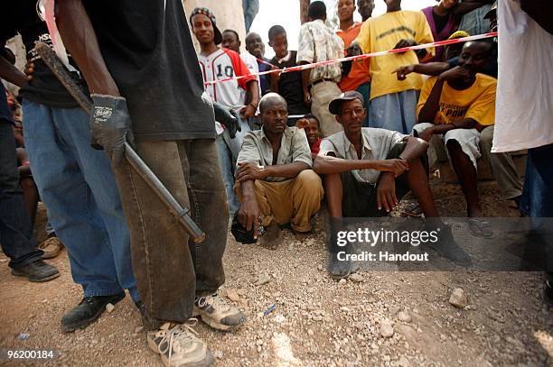 In this handout image provided by the United Nations Stabilization Mission in Haiti , people wait to collect water as the Agency for Technical...