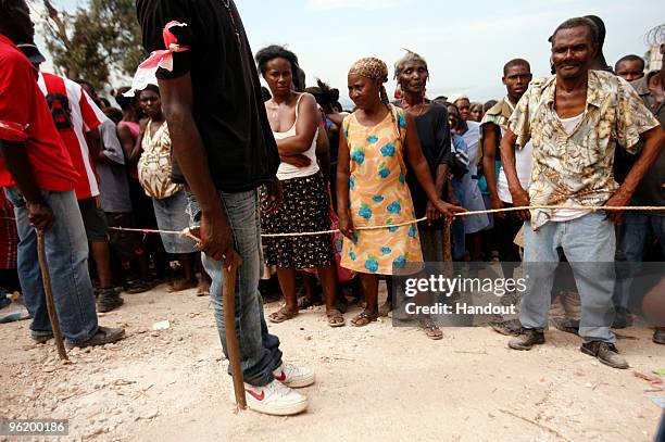 In this handout image provided by the United Nations Stabilization Mission in Haiti , people wait to collect water as the Agency for Technical...