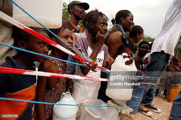 In this handout image provided by the United Nations Stabilization Mission in Haiti , people wait to collect water as the Agency for Technical...