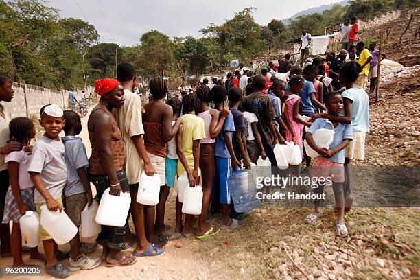 In this handout image provided by the United Nations Stabilization Mission in Haiti , people wait to collect water as the Agency for Technical...