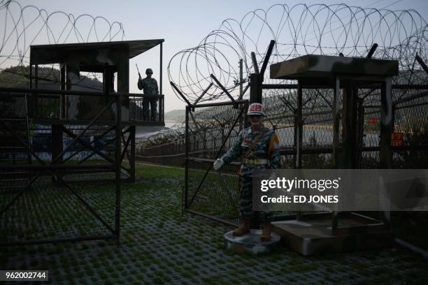 Mannequins of South Korean soldiers stand before a guard post open to visitors, beside the barbed wire fence of the Demilitarized Zone between North...