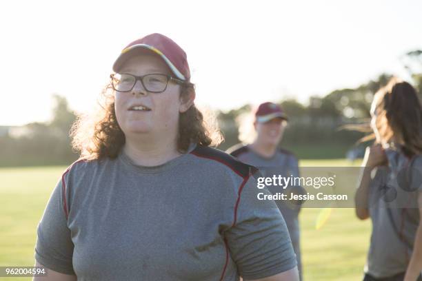 a female sports player watches the action on a sports field - new zealand cricket stock pictures, royalty-free photos & images