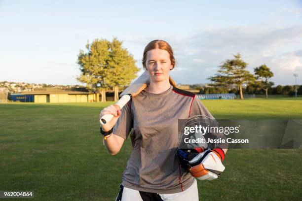 portrait of a female cricketer with bat on sports field - new zealand cricket stock pictures, royalty-free photos & images