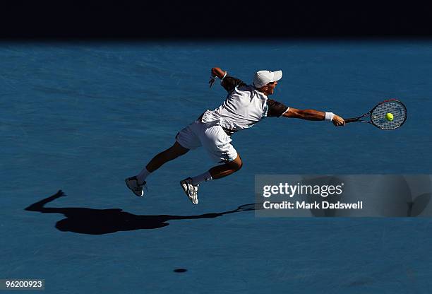 Nikolay Davydenko of Russia plays a backhand in his quarterfinal match against Roger Federer of Switzerland during day ten of the 2010 Australian...