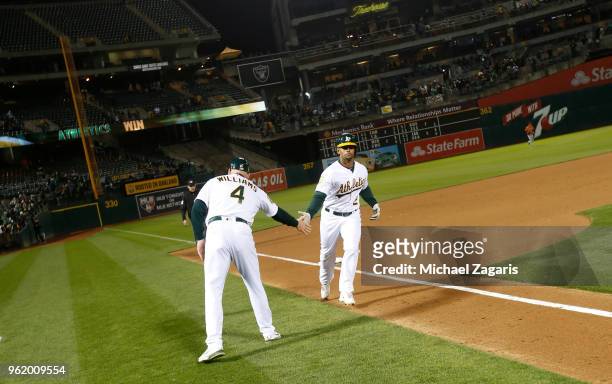 Khris Davis of the Oakland Athletics is congratulated by Third Base Coach Matt Williams while running the bases, after hitting a walkoff home run,...