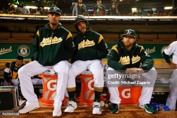 Sean Manaea, Daniel Mengden and Brett Anderson of the Oakland Athletics sit in the dugout during the game against the Baltimore Orioles at the...