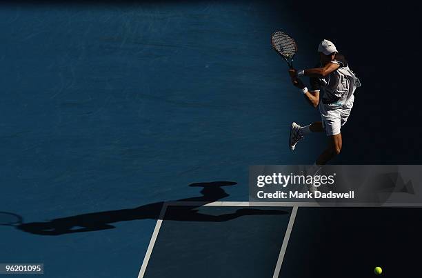 Nikolay Davydenko of Russia plays a backhand in his quarterfinal match against Roger Federer of Switzerland during day ten of the 2010 Australian...
