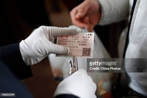 Staff member checks a passenger ticket at the Changchun Railway Station on January 27, 2010 in Changchun of Jilin Province, China. China's National...