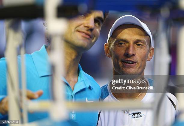 Nikolay Davydenko of Russia and Roger Federer of Switzerland embrace after their quarterfinal match during day ten of the 2010 Australian Open at...