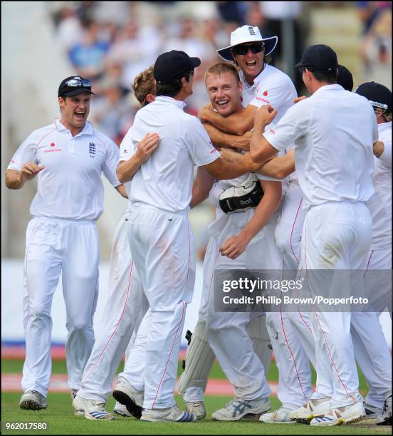 Andrew Flintoff of England is congratulated by captain Michael Vaughan and teammates after taking the wicket of South Africa's Jacques Kallis during...