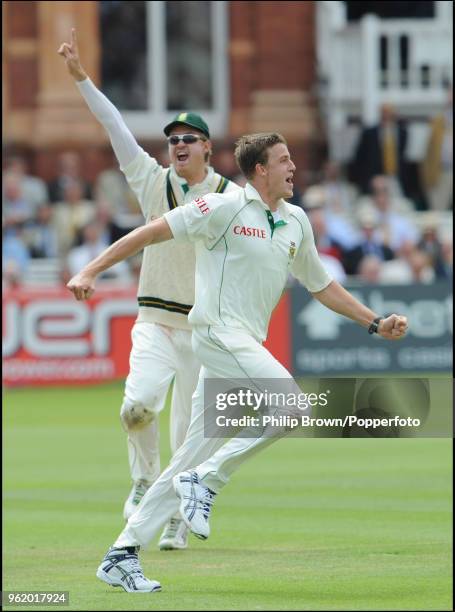 Morne Morkel and Paul Harris of South Africa celebrate the wicket of England's Andrew Strauss during the 1st Test match between England and South...