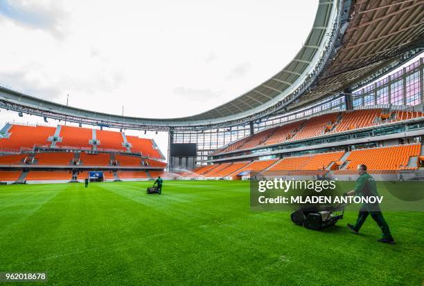 Employees work on the pitch of Ekaterinburg Arena in Yekaterinburg on May 24, 2018. - The 35,000-seater stadium will host four group matches of the...