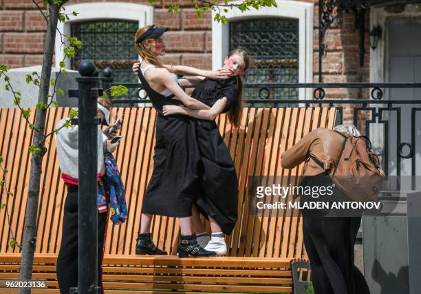 Girls pose for pictures on a bench in Yekaterinburg on May 24, 2018.